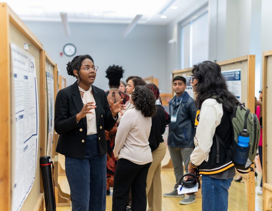 student explaining her research to group of people