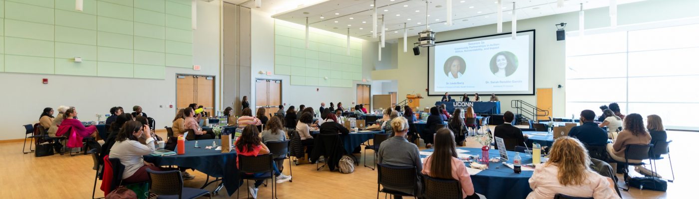 People gathered in a large room, sitting at tables