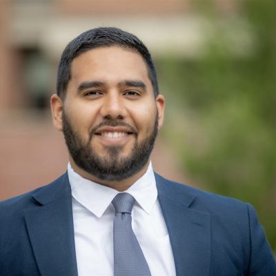 man in shirt tie and blazer smiling