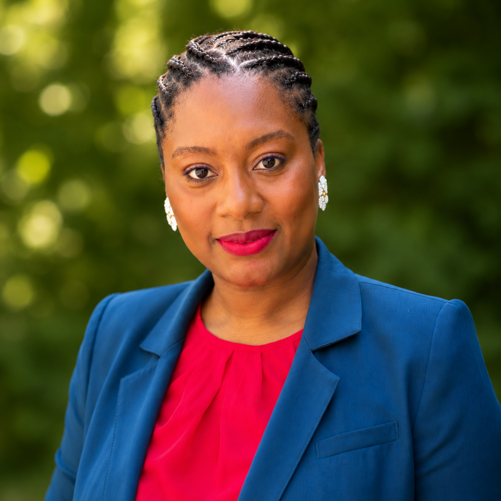 woman with braids wearing a blue blazer and red blouse