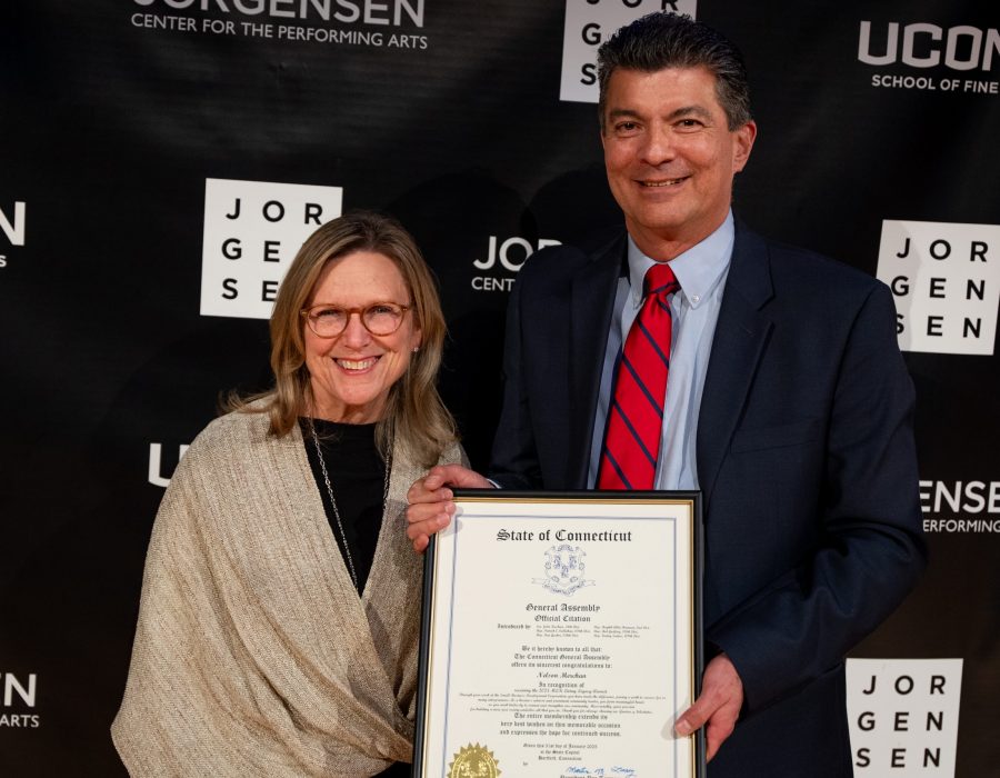 man and woman holding award citation smiling at camera